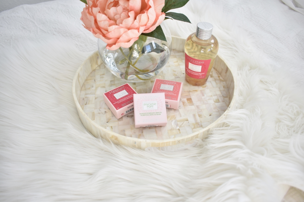 L'Occitane Peony face masks and oil cleanser on mother of pearl tray and faux sheep skin rug