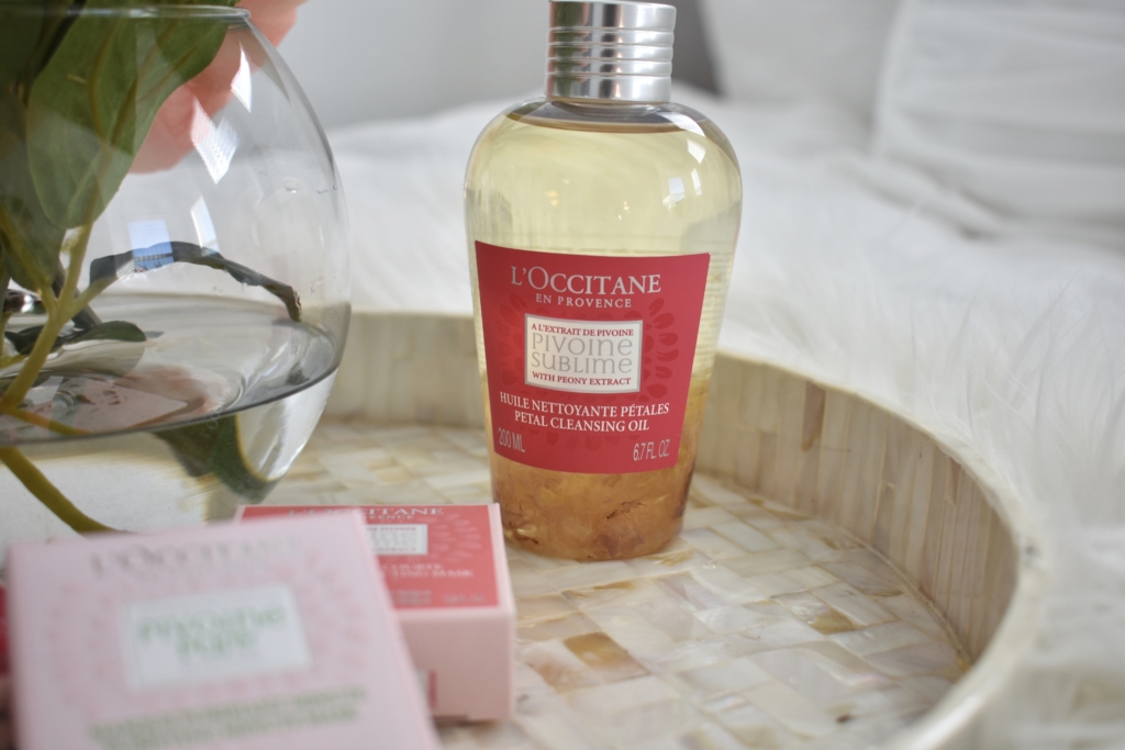 L'Occitane Peony face masks and oil cleanser on mother of pearl tray and faux sheep skin rug