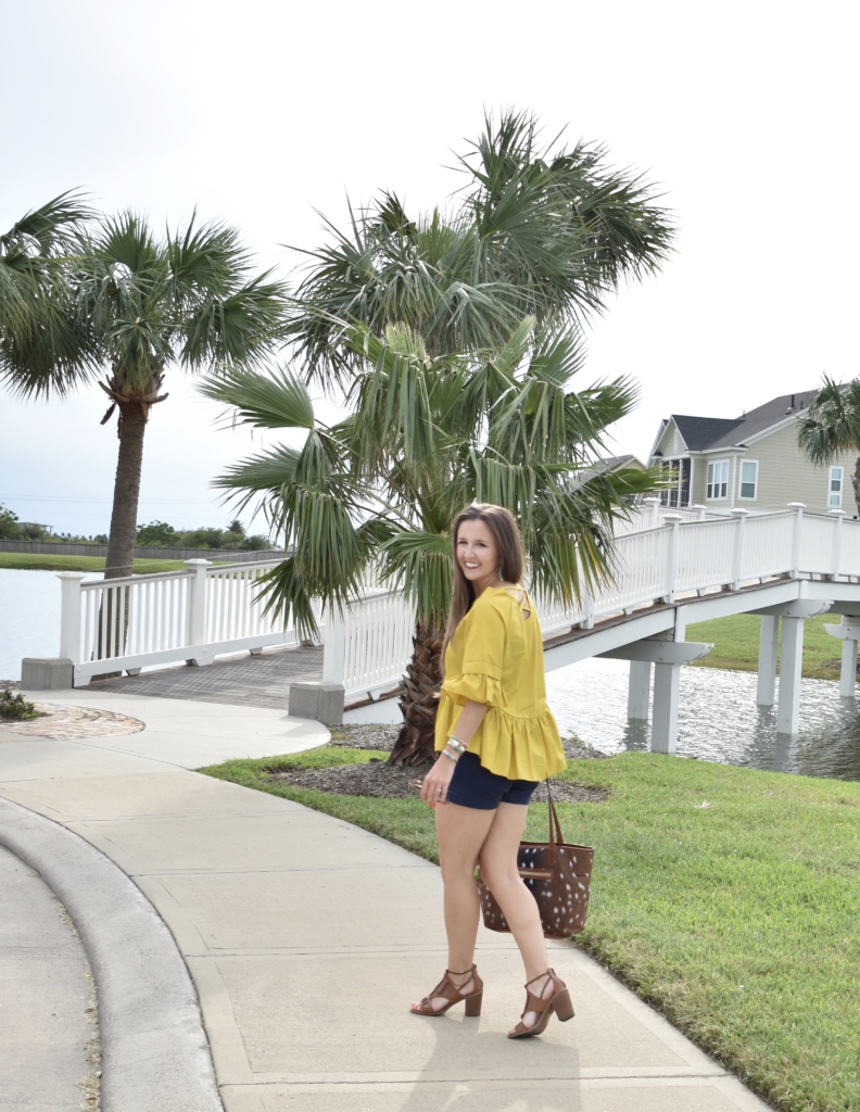 mustard yellow top with navy shorts and axis deer bag
