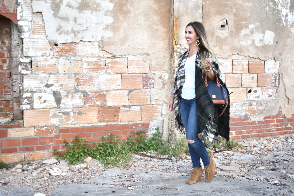 black and white plaid poncho with blue jeans and wedge booties with Dooney & Bourke handbag