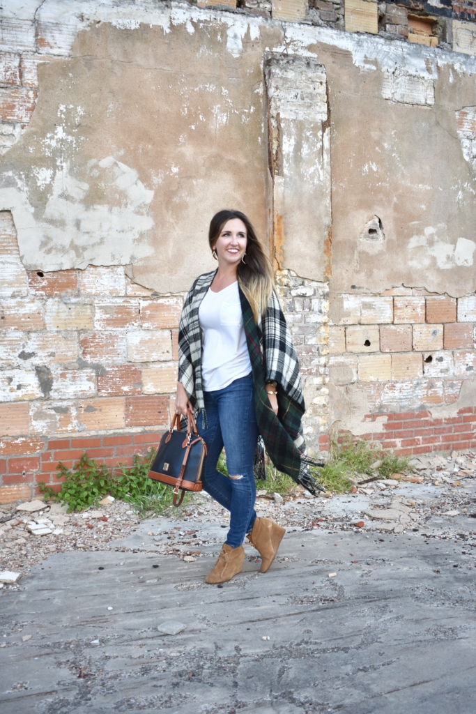 black and white plaid poncho with blue jeans and wedge booties with Dooney & Bourke handbag